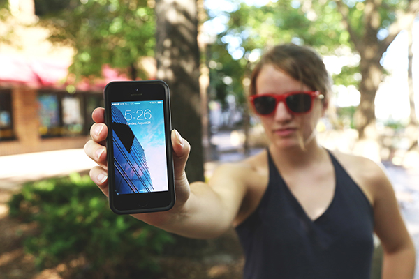 woman wearing sunglasses holding phone facing out