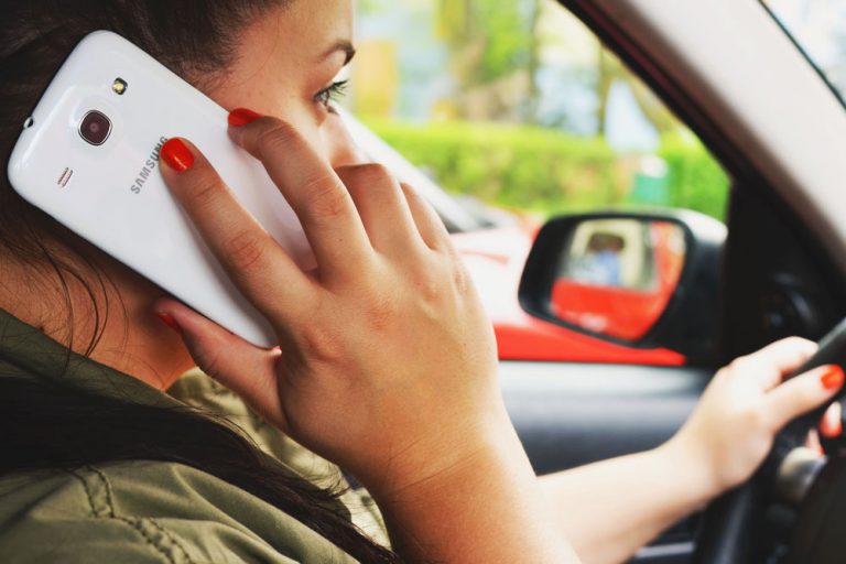 woman talking on smartphone while driving