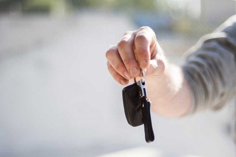 Person holding out car keys as part of the car buying customer journey