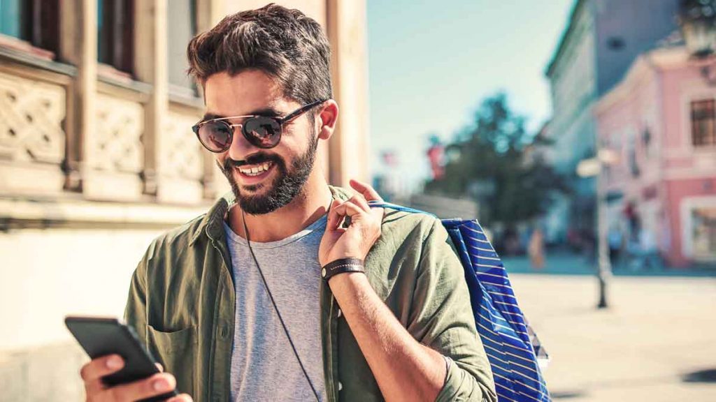 Person with sunglasses using mobile phone while shopping